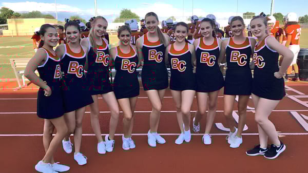 Un grupo de jóvenes estudiantes en uniformes está reunido en el campo de la Boulder Creek High School.