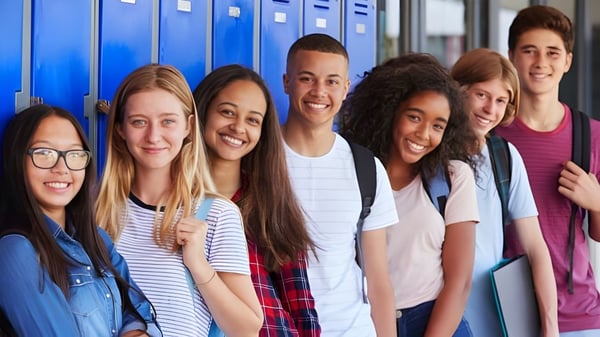 Un grupo de estudiantes está frente a taquillas azules en el campus de Boulder Valley Public Schools.