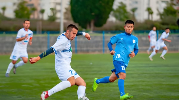 Dos estudiantes juegan al fútbol en el campo deportivo del Bournemouth & Poole College.