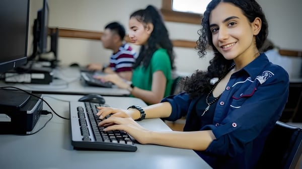 Un grupo de estudiantes trabaja en conjunto en computadoras en el laboratorio del Braemar College.
