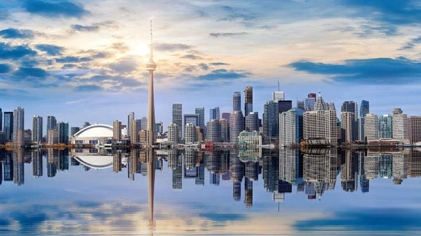 Una impresionante silueta de la ciudad se refleja en aguas tranquilas bajo un cielo dramático en el Braemar College.
