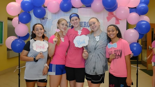 Un grupo de alumnas de la Brevard County Public Schools posan frente a un colorido fondo de globos.