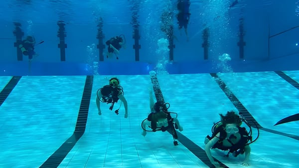 Estudiantes de la Brocklehurst Secondary School participan en un curso de buceo en una gran piscina.