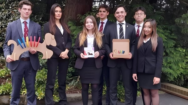 Un grupo de estudiantes de la Bromsgrove School está en la entrega de premios en el área verde.