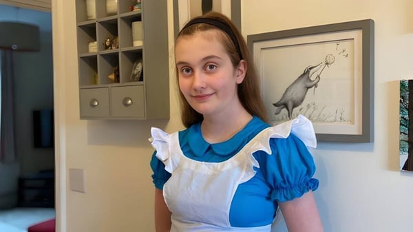 Una joven mujer está en una sala con estanterías y una obra de arte en la pared en el campus de Brookes UK.