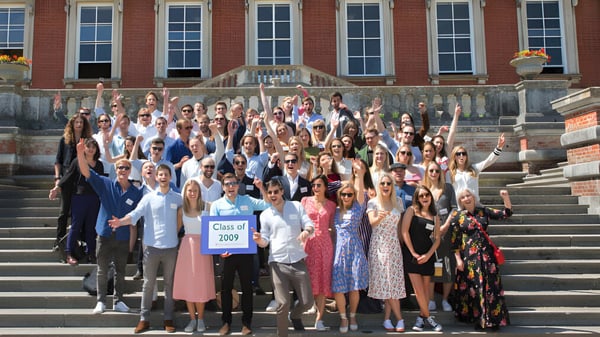 Un grupo de estudiantes está frente al edificio de ladrillo de la Bryanston School sosteniendo un cartel con Class of 2022.