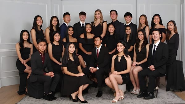 Un grupo de estudiantes de la Burnaby North School posan juntos en una habitación con paredes blancas.