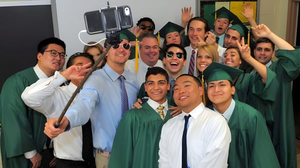 Un grupo de estudiantes de la Burnside State High School celebra juntos su graduación en toga.