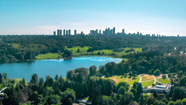 Un panorama de paisaje boscoso con lago y rascacielos lejanos cerca de la Byrne Creek School.