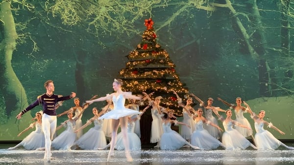 Estudiantes de la Calabasas High School bailan en el escenario frente a un gran árbol de Navidad.