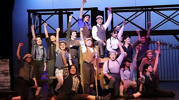 Un grupo de estudiantes de la Caledonia Secondary School está en el escenario durante una representación teatral.