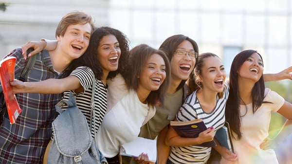 Un grupo de estudiantes del Cambridge Tutors College se abraza riendo al aire libre.