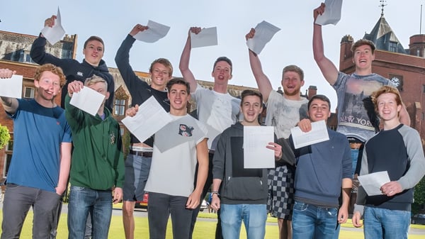 Un grupo de estudiantes celebra afuera frente a un edificio histórico en el campus del Campbell College.