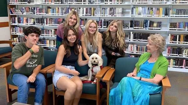 Estudiantes de la Campo Verde High School están juntos en el área de la biblioteca entre estanterías de libros.