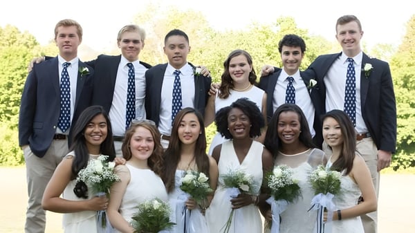 Un grupo de estudiantes de Canterbury School está con flores y en ropa formal frente a árboles en el exterior.