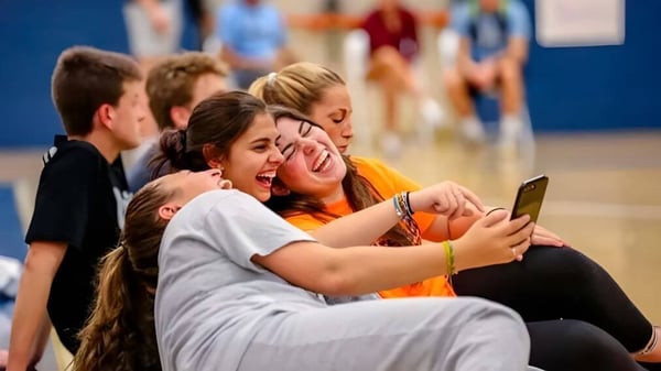 Un grupo de estudiantes de Canterbury School se toma un selfie juntos frente a un fondo colorido.