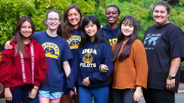 Un grupo de estudiantes sonríe en un área verde al aire libre de la Canyonville Academy.