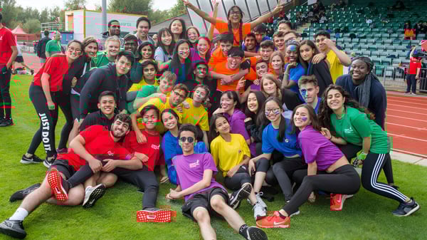 Un grupo de jóvenes mujeres en ropa deportiva se reúne para una foto grupal en el campo de deportes del Cardiff Sixth Form College.