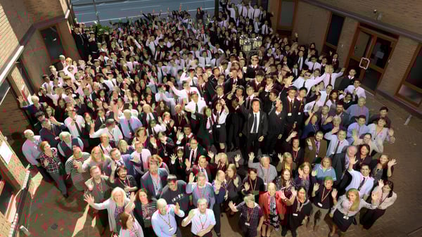 Un gran grupo de estudiantes en la entrada del Cardiff Sixth Form College se reúne.