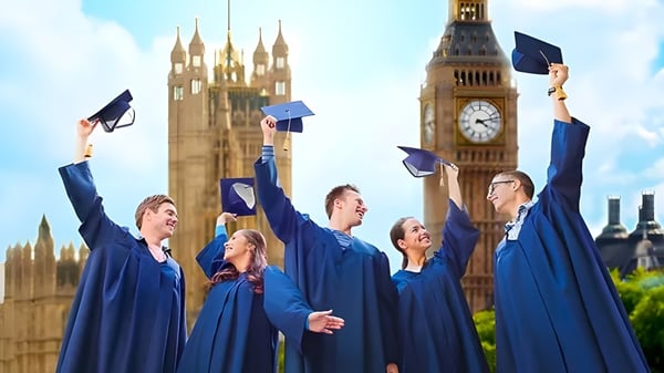 Un grupo de graduados del Carfax College celebra su graduación frente al Big Ben y el Palacio de Westminster.