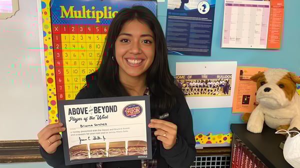 Una estudiante de la Carl Schurz High School sostiene en un aula un libro titulado Above & Beyond: Players of the Week.