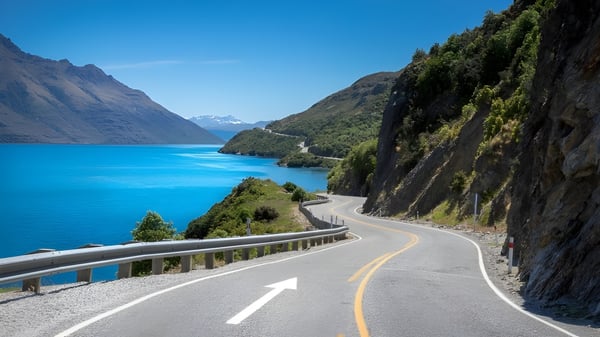 Una carretera sinuosa a lo largo de un lago turquesa muestra el paisaje natural cerca del Carmel College.