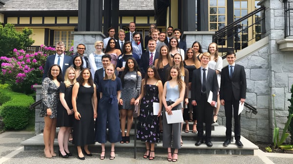Un grupo de estudiantes está de pie juntos en las escaleras de un edificio histórico en el campus de la Carson Graham Secondary School.