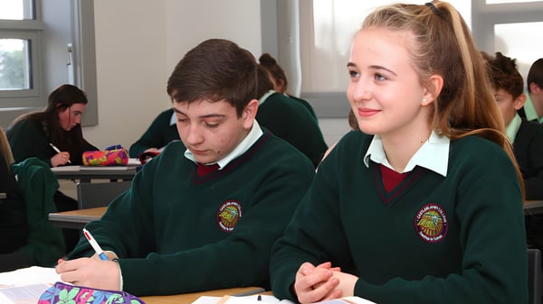 Dos estudiantes en uniforme escolar están sentados en el aula en el campus de Castleblayney College.