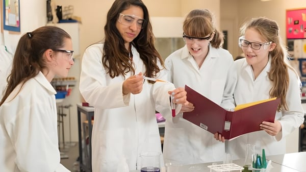 Las estudiantes de la Castlerea Community School examinan documentos juntas en un laboratorio.