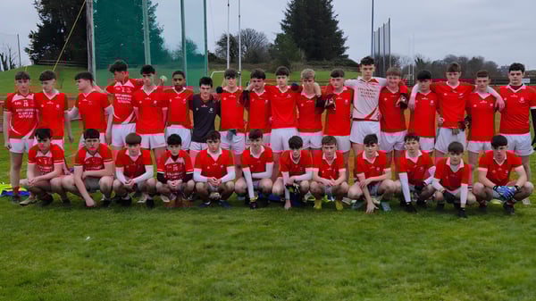 Un gran grupo de jóvenes futbolistas en camisetas rojas está en el campo deportivo de la C.B.S. Roscommon.