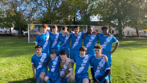 Un grupo de jóvenes futbolistas en camisetas azules en un campo verde en el campus de CBS Westland Row.