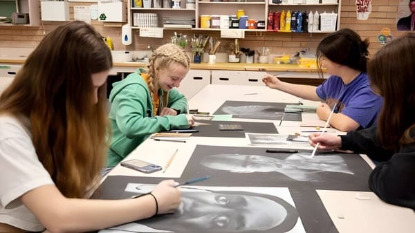 Las estudiantes trabajan juntas en una mesa en el estudio de arte del Centennial Collegiate.