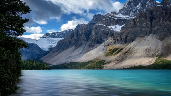 El tranquilo lago turquesa frente a montañas nevadas en el terreno del Centennial Collegiate.