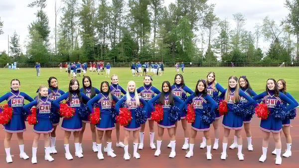 Un grupo de animadoras está en el campo de césped en el campus de la Centennial Secondary School en British Columbia.