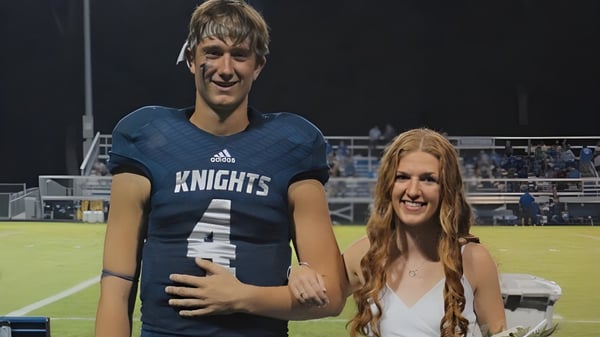 Dos estudiantes de la Central Catholic Jr.-Sr. High School están en el campo deportivo con ropa deportiva.