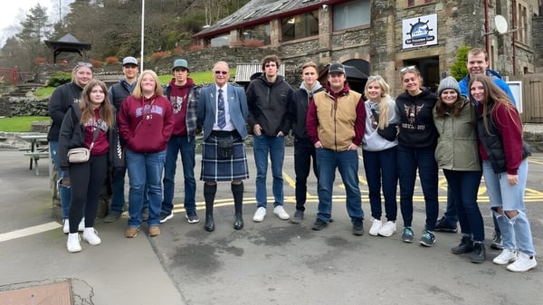 Un grupo de estudiantes está frente al edificio rústico en el campus de la Central High Sedgewick Public School.