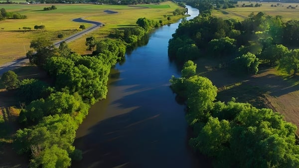 Un río tranquilo fluye a través de un paisaje verde cerca de la Central Yorke School.