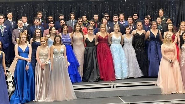 Un grupo de personas en vestidos de noche formales está en el escenario de la Central High Sedgewick Public School.