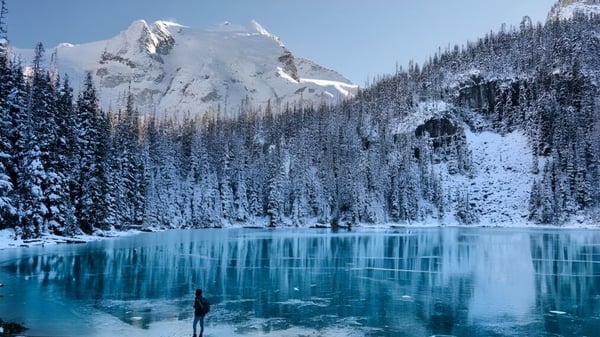 Paisaje montañoso nevado con lago y bosque de pinos cerca de la Centre Dufferin District High School.