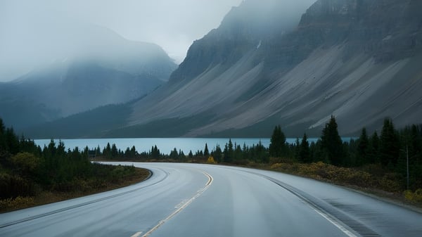 Una carretera sinuosa atraviesa un paisaje montañoso neblinoso cerca de la Centre Wellington District High School.