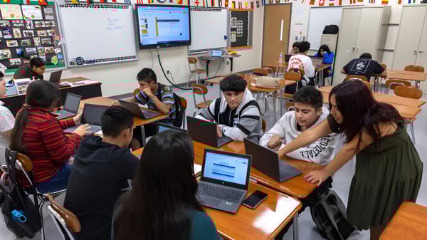 Estudiantes de las Charlotte-Mecklenburg Schools trabajan en el aula en computadoras rodeados de materiales de aprendizaje.