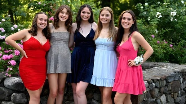 Cinco alumnas de la Chatham Hall School están juntas en un jardín lleno de flores.