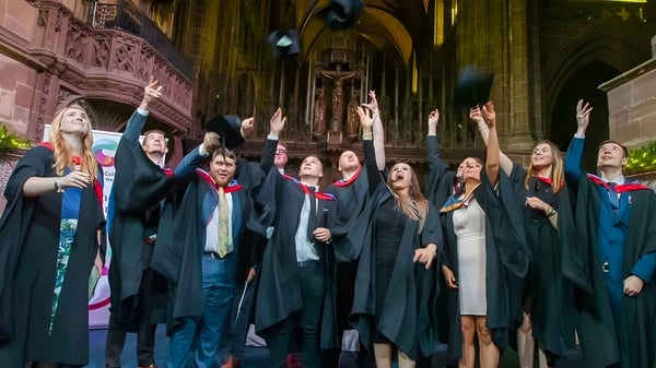 Las graduadas y graduados de Cheshire College South & West celebran su fiesta de graduación en un magnífico salón similar a una catedral.