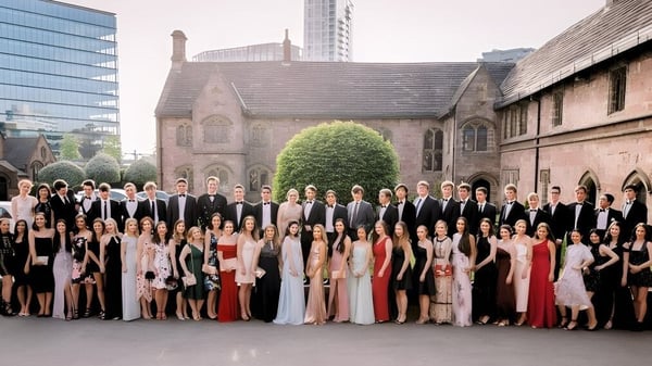 Un grupo de personas en ropa formal está frente a una iglesia histórica en el terreno de la Chetham’s School of Music.