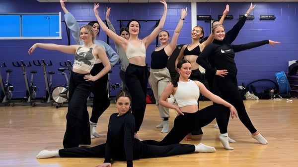 Un grupo de mujeres en ropa deportiva posando juntas en el estudio de danza del Chichester College.