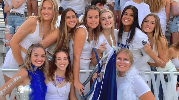Un grupo de estudiantes del Chico Unified School District está en el área exterior frente a un estadio y sonríe a la cámara.