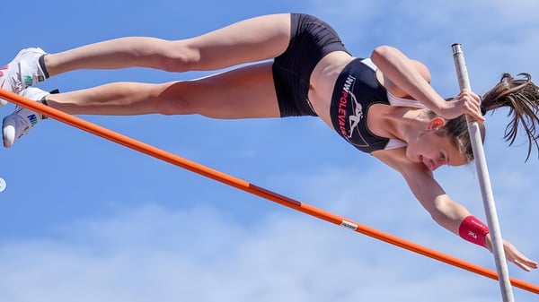Una estudiante de la Chief Sealth High School realiza el salto de altura sobre la barra naranja durante el deporte.