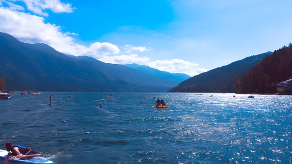 El lago con actividades acuáticas frente al telón de fondo de montañas en el terreno de la Chilliwack Secondary School.