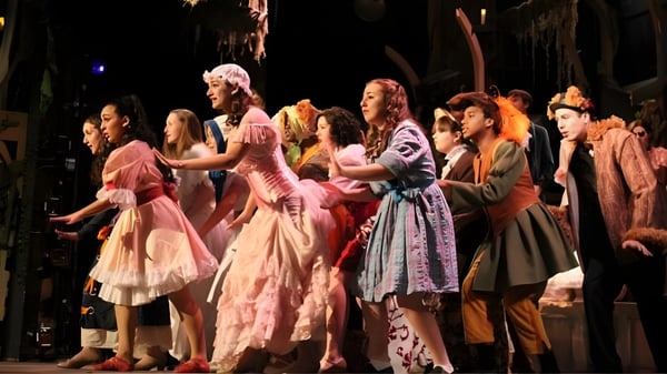 Estudiantes del Chino Valley Unified School District presentan una escena en el escenario con coloridos disfraces.