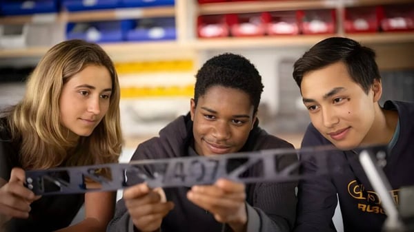 Tres estudiantes de Choate Rosemary Hall miran juntos un documento en un aula.